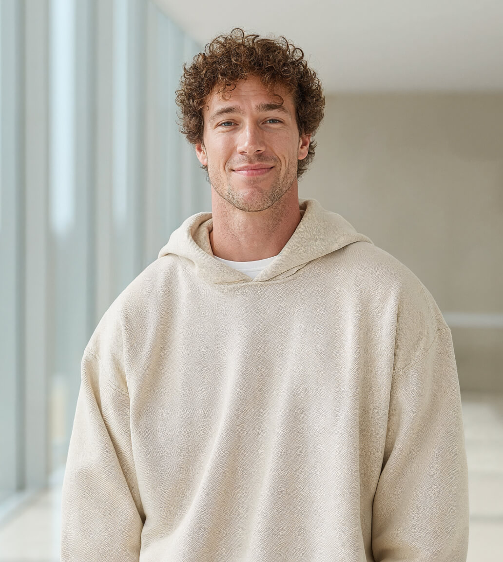 Smiling Man Curly Hair Hoddie - Longevity Webflow Template | Brix Templates